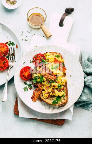 Rührei, Speck und gegrillte Tomaten auf Toast Stockfoto