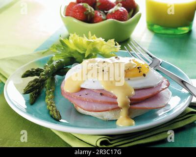 Kanadischer Speck und ein Spiegelei mit Hollandaise-Sauce auf einem englischen Muffin mit Spargel Stockfoto