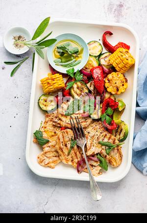 Gegrillte Schweinesteaks mit Salbeibutter und gegrilltem Gemüse Stockfoto