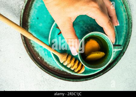 Würziger grüner Tee, serviert in der Teetasse in Frauenhänden Stockfoto