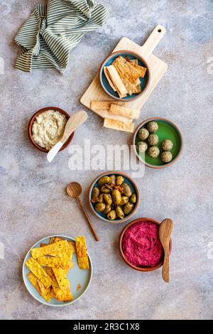 Auswahl an hausgemachten Crackern, gegrillten Oliven, LabGO-Bällen, Rote-Beete-Hummus und Moutabel Stockfoto