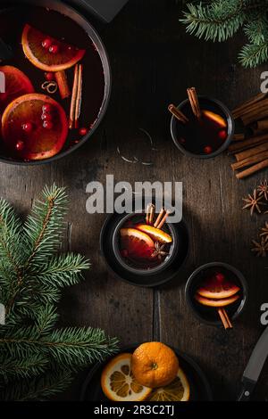 Glühwein in Bechern mit Orangenscheiben auf einem Holztisch Stockfoto
