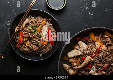 Schüssel mit asiatischem Hähnchen, gebratene Soba-Nudeln mit Gemüse Stockfoto