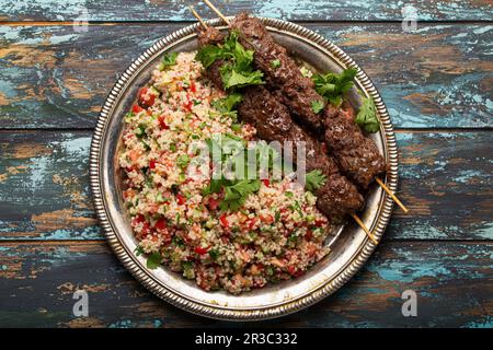 Nahöstliches türkisches Abendessen mit Fleischkebab und Couscous-Salat Tabbouleh Stockfoto