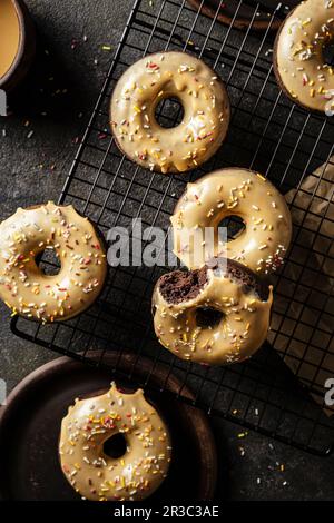 Glasierte Schokoladendonuts mit Karamellglasur und Streuseln Stockfoto