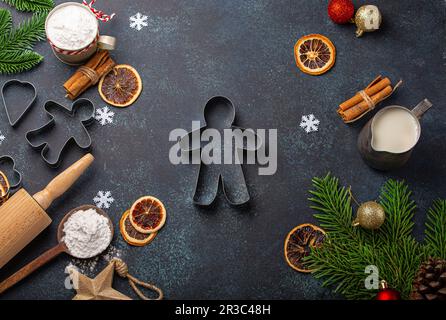 Weihnachtsbacken: Küchengeräte, Mehl, Tannenbaum und Lebkuchen-Mann-Cutter Stockfoto