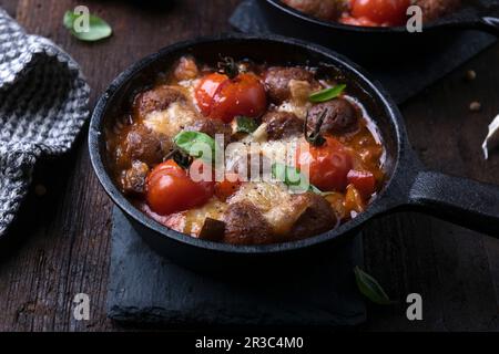 Vegane "Fleischbällchen" in Gemüse-Tomatensoße mit Pflanzenkäse Stockfoto