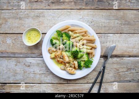 Hühnerkoteletts mit Brokkoli und Vollnudeln Stockfoto