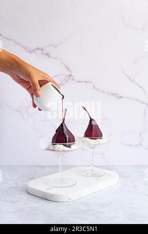 Pochierte Birnen mit würziger Rotweinreduktion Stockfoto