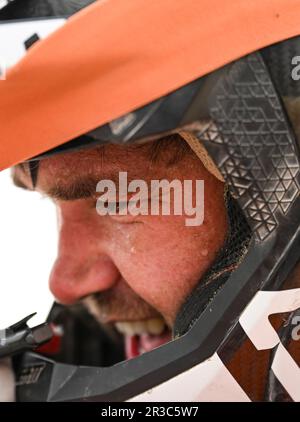 Maigaiti, Chinas autonome Region Xinjiang Uygur. 23. Mai 2023. Motorradfahrer Samuel Jackson Charles Brown aus Neuseeland reagiert nach der dritten Etappe in der Wüste von Maigaiti County auf der Taklimakan Rally 2023, der Autonomen Region Xinjiang Uygur im Nordwesten Chinas, 23. Mai 2023. Kredit: Hu Huhu/Xinhua/Alamy Live News Stockfoto