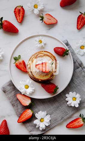 Kleine Pfannkuchen mit Erdbeeren und Puderzucker Stockfoto