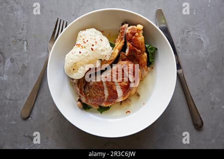 Schweinekotelett, Brühe und knusprige Schweinehaut Stockfoto