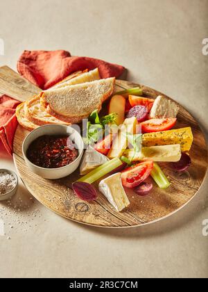 Englischer Käse mit Chutney und Brot auf einer Holzplatte Stockfoto