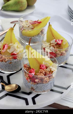 Dessert mit Chia, Müsli und Birnen in Kurkuma gekocht Stockfoto