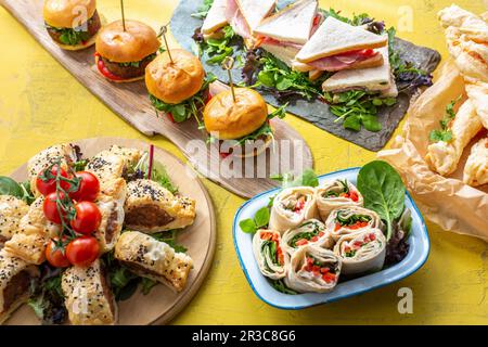 Sandwiches, Käsestifte, Mini-Burger, Wraps und Würstchen in Gebäck Stockfoto