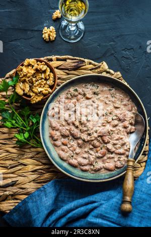 Traditionelle georgische Logio mit Walnüssen auf Betontisch serviert Stockfoto