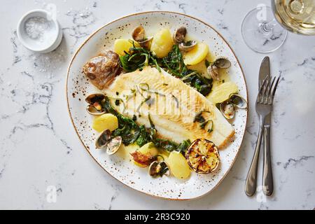 ZitronenSeezunge mit Muscheln, Kartoffeln und grünem Gemüse Stockfoto