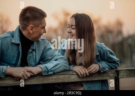 Nahaufnahme eines lächelnden, wunderschönen jungen Paares auf der Bank im Park Stockfoto