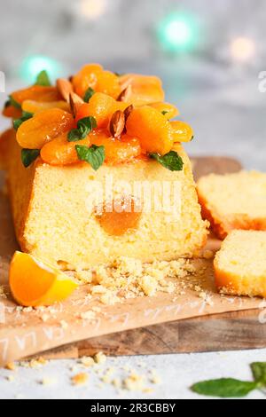 Orangenkuchen mit frisch gepresstem Orangensaft und Schale mit getrockneten Aprikosen Stockfoto