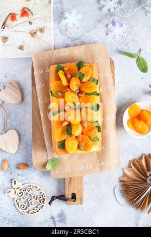 Orangenkuchen mit frisch gepresstem Orangensaft und Schale mit getrockneten Aprikosen Stockfoto