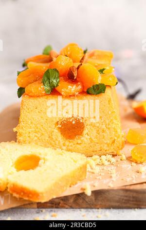 Orangenkuchen mit frisch gepresstem Orangensaft und Schale mit getrockneten Aprikosen Stockfoto