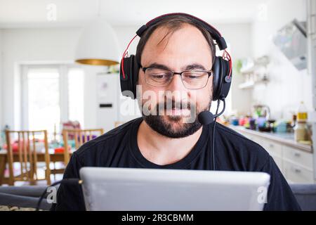 Erwachsene junge Mann im Headset sprechen von Webcam Stockfoto