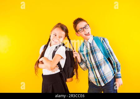 Die glücklichen Schulkinder, die zwischen den Studien Spaß haben Stockfoto