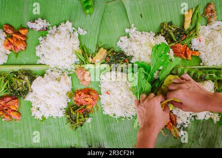 Nasi liwet, ein traditionelles indonesisches Essen, serviert auf Bananenblättern, wird von oben gesehen Stockfoto