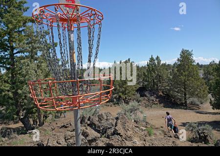 Eine Studentin, die auf dem Pine Nursery Course in Bend, Oregon, Disc Golf spielt. Stockfoto