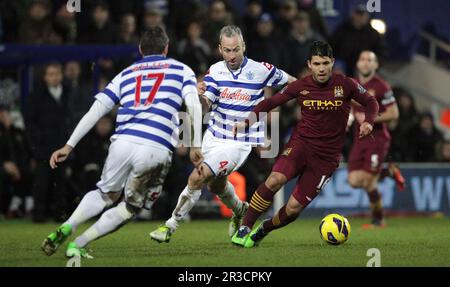 Manchester Citys Sergio Aguero unter Druck von Queens Park Rangers' Ryan Nelsen (L) und Queens Park Rangers' Shaun Derry (M). Das Spiel endet mit einem Stockfoto