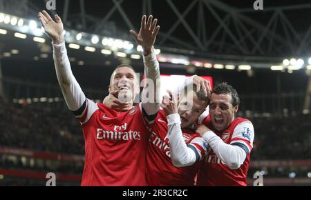 Arsenals Lucas Podolski feiert sein drittes Tor mit Arsenals Jack Wilshere (M) und Arsenals Santi Cazorla. Arsenal schlägt Newcastle Stockfoto