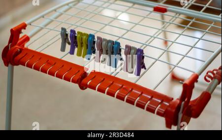 Mehrfarbige Wäscheständer/Kleiderpfosten auf einem zusammenklappbaren/zusammenklappbaren Wäscheständer. Stockfoto