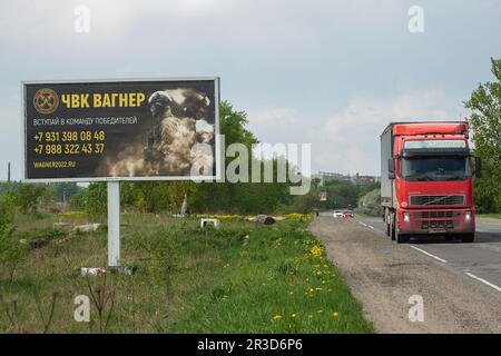 Sankt Petersburg, Russland. 22. Mai 2023. Ein Lkw fährt an einer Plakatwand vorbei, auf einer Autobahn in der Nähe von St. Petersburg in der Region Leningrad mit russischen Soldaten und einer Anzeige für eine private Militärfirma, PMC Wagner, mit der Aufschrift „Join the winning Team“. Am 20. Mai 2023 erklärte der Gründer einer privaten Militärgesellschaft, Yevgeny Prigozhin, dass die PMC Wagner Group die Stadt Bakhmut vollständig unter ihre Kontrolle genommen habe. (Foto: Artem Priakhin/SOPA Images/Sipa USA) Guthaben: SIPA USA/Alamy Live News Stockfoto