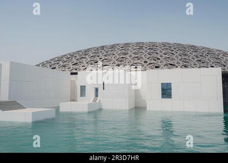 Abu Dhabi, VAE - 21. März 2023 : Außenansicht des berühmten Museums Louvre Abu Dhabi. Schlichte weiße Wände, die einen smaragdgrünen Graben umgeben, der von einem Ornat gekrönt ist Stockfoto