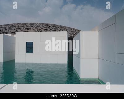 Abu Dhabi, VAE - 21. März 2023 : Außenansicht des berühmten Museums Louvre Abu Dhabi. Schlichte weiße Wände, die einen smaragdgrünen Graben umgeben, der von einem Ornat gekrönt ist Stockfoto