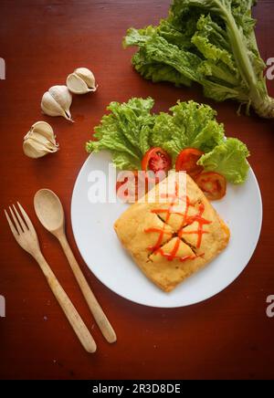 nasi goreng pattaya oder Pattaya Fried Rice (gefüllter Omelette Fried Rice). Südostasiatisches Gericht, das durch Abdecken oder Umhüllen von gebratenem Reis mit Hühnchen in dünner Form hergestellt wird Stockfoto