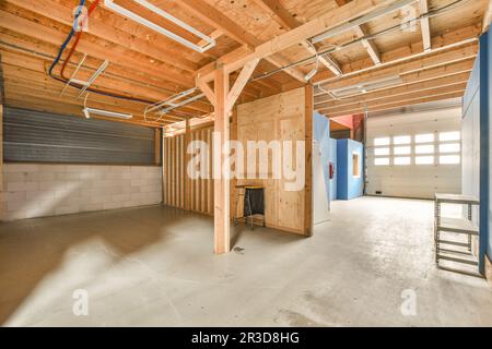 Eine unfertige Garage, die als Lagerraum für Autos und andere Fahrzeuge verwendet wird, die in der Garage geparkt sind Stockfoto