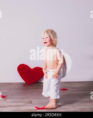 Der fröhliche kleine Junge hat am Valentinstag Spaß Stockfoto