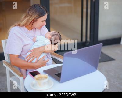 Porträt von verschiedenen Menschen. Kreative Geschäftsfrau, die Arbeit und Mutterschaft in Einklang bringt. Wunderschöne junge Mutter, die mit einem Laptop arbeitet und stillt, Stockfoto