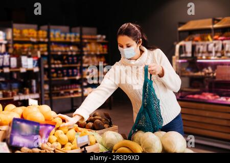 Junge Frau, die umweltfreundliche Art des Einkaufens wählt Stockfoto