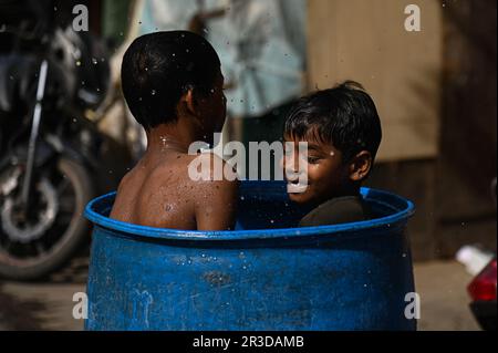 New Delhi, Delhi, Indien. 23. Mai 2023. Kinder nehmen an einem heißen Sommertag vor einem Slum-Cluster in Neu-Delhi, Indien, am 23. Mai 2023 ein Bad in einem Wasserbehälter. (Kreditbild: © Kabir Jhangiani/ZUMA Press Wire) NUR REDAKTIONELLE VERWENDUNG! Nicht für den kommerziellen GEBRAUCH! Stockfoto