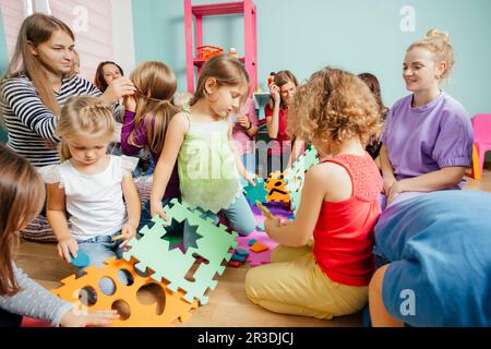 Gruppe von jungen Müttern mit ihren Kindern in der Kindertagesstätte Stockfoto