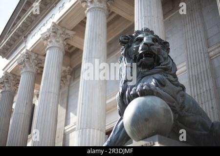 Einer der beiden Löwen am Eingang zum spanischen Abgeordnetenkongress (Congreso de los Diputados). Madrid, Spanien. Stockfoto
