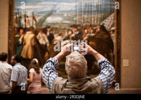 Ein Tourist im Prado Museum, der ein Foto des berühmten Gemäldes von Velazquez „die Kapitulation von Breda“ macht. Madrid, Spanien. Stockfoto