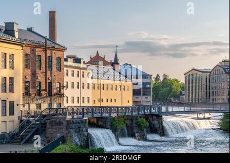 Die alte Industrielandschaft und der Motala Fluss an einem Frühlingsabend in Norrköping. Norrköping ist eine historische Industriestadt in Schweden. Stockfoto