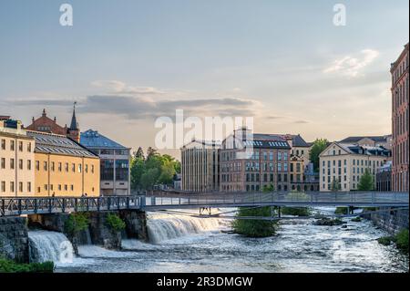 Die alte Industrielandschaft und der Motala Fluss an einem Frühlingsabend in Norrköping. Norrköping ist eine historische Industriestadt in Schweden. Stockfoto