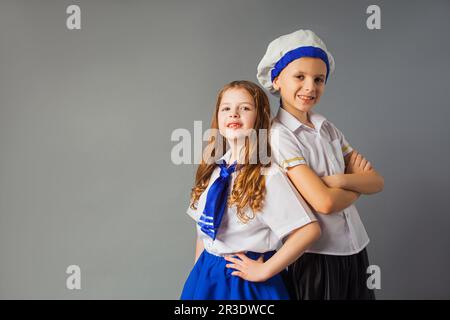 Das glückliche kleine Paar in den Kostümen eines Matrosen Stockfoto