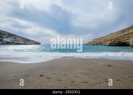 Panorama von Matala Beach mit den Höhlen auf den Felsen, die als römischer Friedhof genutzt wurden und in den 70er Jahren lebten Hippies, Kreta, Griechenland Stockfoto