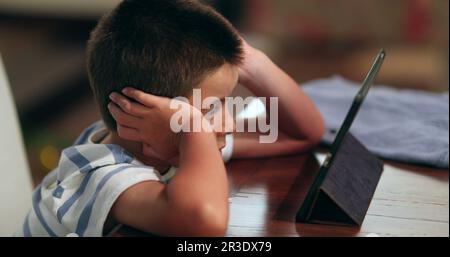 Ein Kind sieht sich einen Film auf dem Tablet an. Das Kind wurde von Online-Inhalten hypnotisiert Stockfoto