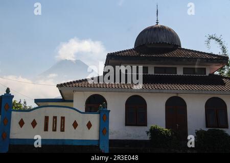 Sleman, Yogyakarta, Indonesien. 21. Mai 2023. Auf dem Gipfel des Berges Merapi können Sie vor dem Vordergrund einer Moschee in Sleman, Yogyakarta, Indonesien, am Sonntag, den 21. Mai, 2023. Daten des Forschungszentrums für Forschung und Entwicklung auf dem Gebiet der geologischen Katastrophentechnologie (BPPTKG) vom Dienstag, dem 23. Mai 2023, belegen, dass glühende Lava beobachtet wurde. 26-mal mit einer maximalen Rutschstrecke von 2000 Metern nach Südwesten oder zum Fluss Bebeng. (Kreditbild: © Slamet Riyadi/ZUMA Press Wire) NUR REDAKTIONELLE VERWENDUNG! Nicht für den kommerziellen GEBRAUCH! Stockfoto